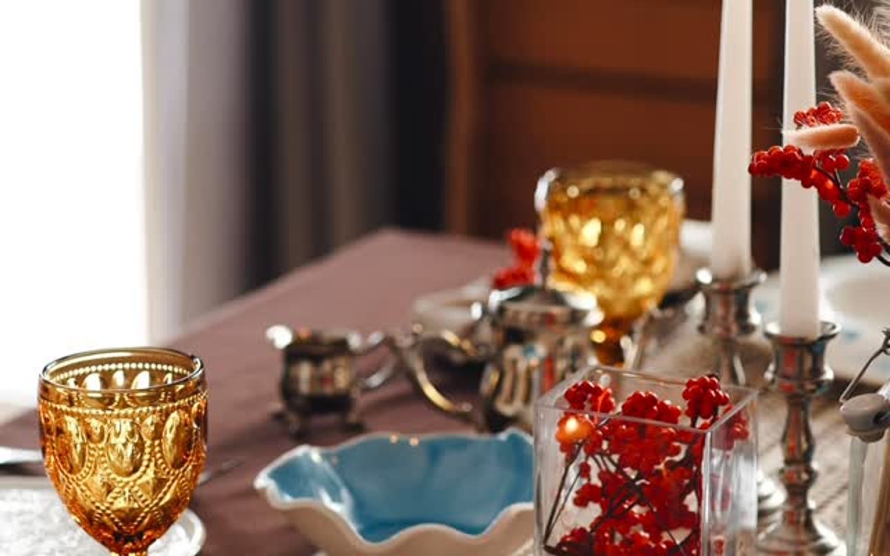 Стол со свечами, янтарными бокалами и голубой керамической пиалой из профиля Iskra Pottery
